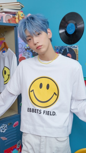 Soobin from TXT wearing a smiley face t-shirt