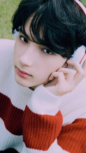 Huening Kai from TXT wearing headphones