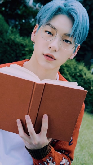 Soobin from TXT holding a book