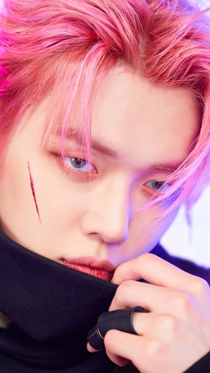 Yeonjun from TXT with pink hair and scar