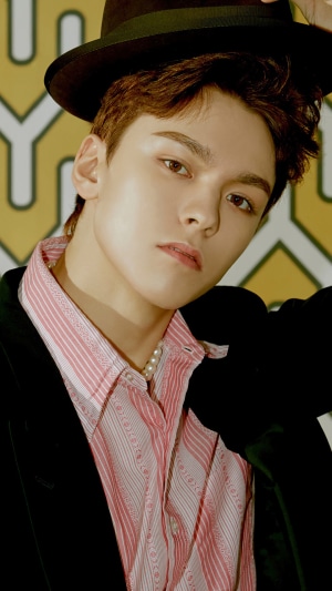 Vernon from Seventeen wearing a hat and pink shirt
