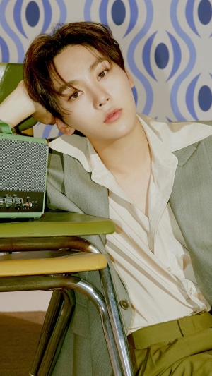 Seungkwan from Seventeen posing with a vintage radio