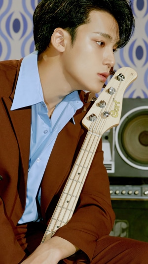Kim Mingyu from Seventeen holding a bass guitar