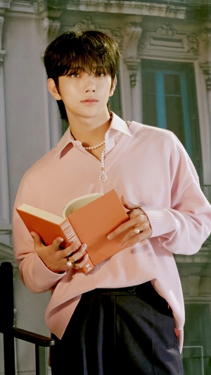 Joshua Hong from Seventeen holding a book