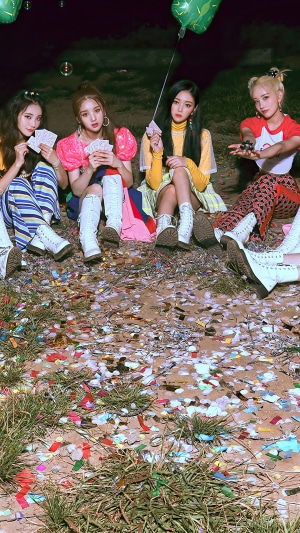 Four girls from Loona sitting on the ground with cards