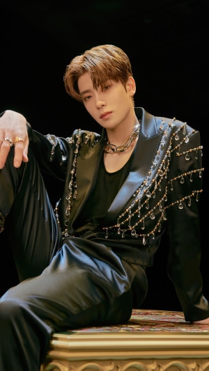Jaehyun from NCT U sitting in a black suit