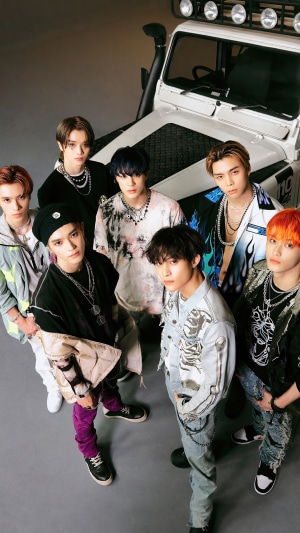 NCT U members posing in front of a vehicle