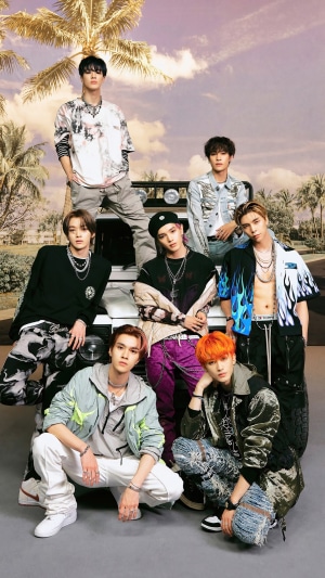 NCT U members posing in front of a car