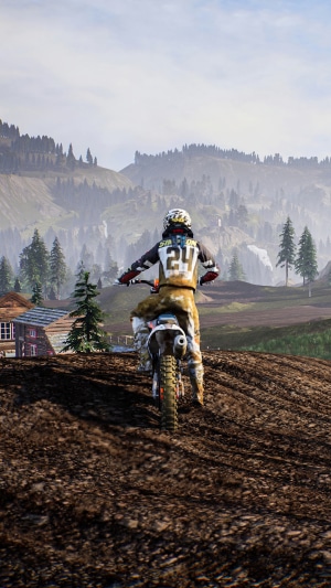 Motocross rider on a dirt track in a mountainous landscape