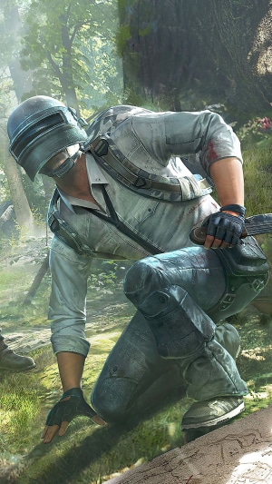 Player in PUBG armor crouches in a forest