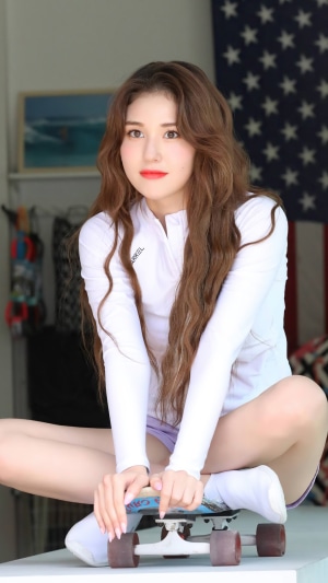 Jeon Somi sitting on a skateboard