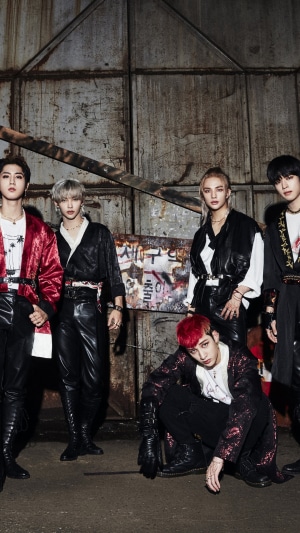 Stray Kids members posing in front of a metal wall