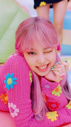 Jennie from BLACKPINK winking in a pink outfit