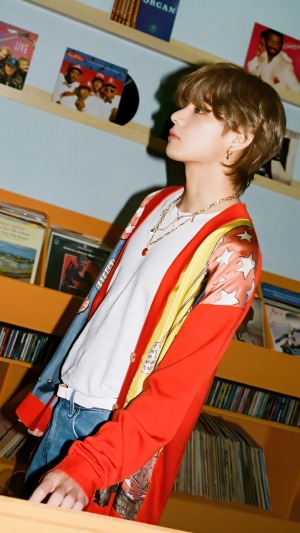 V from BTS Kpop standing in front of record shelves