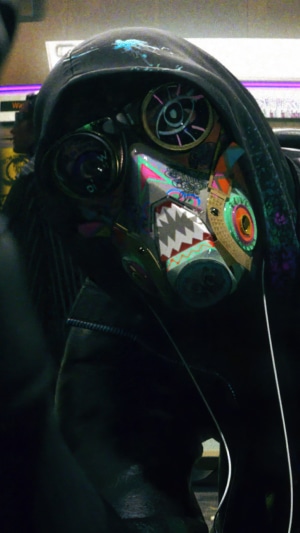 Person wearing a colorful mask from Watch Dogs Legion