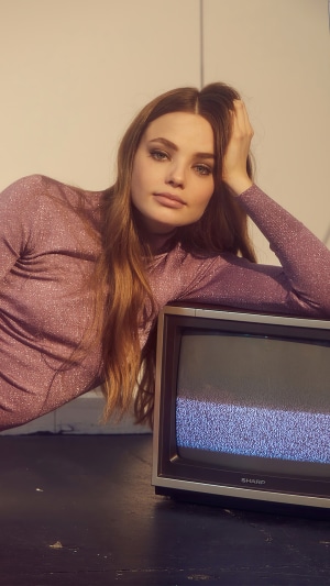Kristine Froseth posing with a vintage television