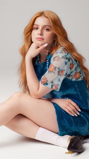 Ariel Winter sitting on a white background