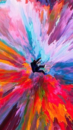 Astronaut falling through colorful abstract explosion
