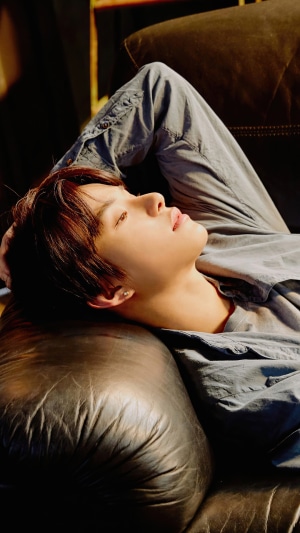 Jungwoo from NCT 127 lying on a couch