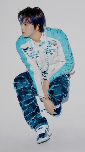 Haechan from NCT 127 wearing a racing jacket and jeans