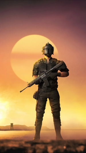 Player in PUBG armor holding a rifle at sunset