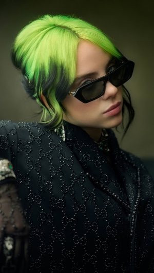Billie Eilish wearing sunglasses and a beaded jacket