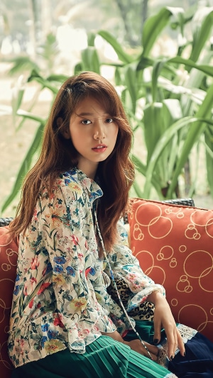 Park Shin-hye sitting on a couch with plants in the background