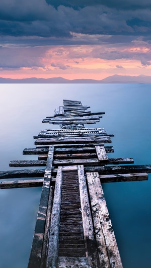 Old wooden pier on a calm sea at sunset