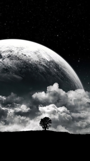 A lone tree on a hill under a large moon