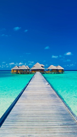 Wooden pier leading to overwater bungalows in the Maldives