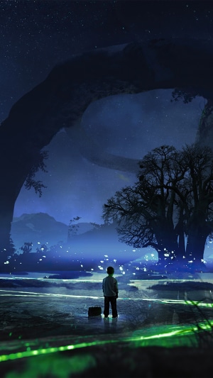 Boy standing in a surreal landscape at night