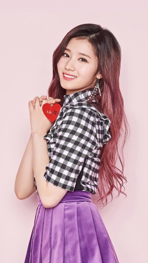Sana from TWICE holding a red heart