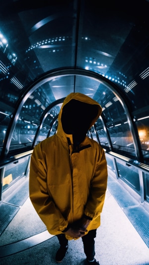 Person in yellow hoodie in futuristic tunnel 4K