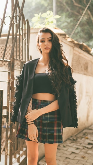 Model in a black jacket and plaid skirt