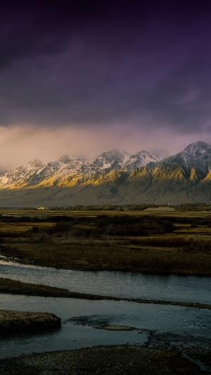 Snow-capped mountains at sunrise over a river