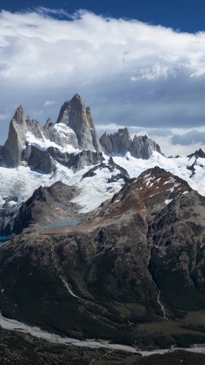 Snow-capped mountains under a cloudy sky