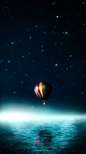 Hot air balloon over water at night