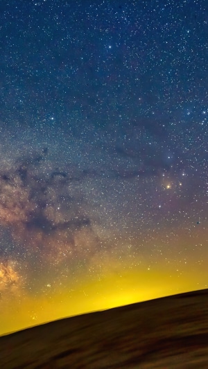 Night sky with stars and the Milky Way over a landscape