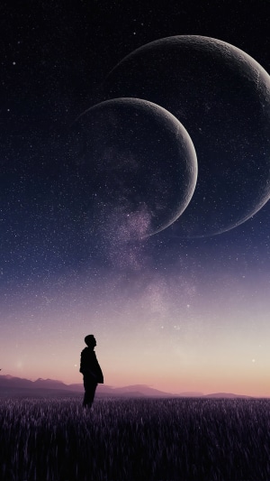 Man looking at two moons in starry sky 4K