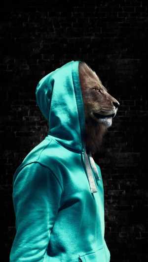 Lion wearing a teal hoodie against a brick wall