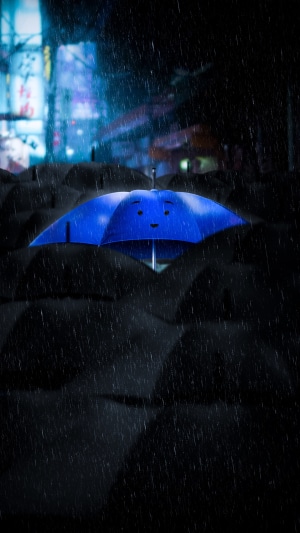 Blue umbrella with a face in the rain