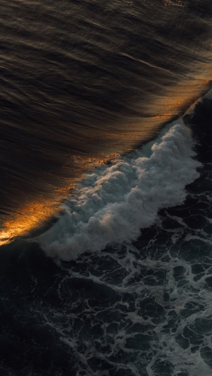 Ocean wave with golden light reflection 4K
