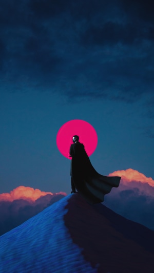 Warrior in a cape on a sand dune at sunset