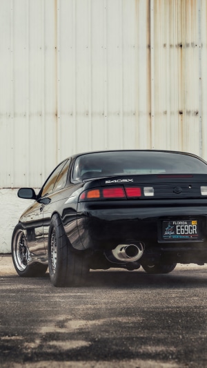 Black Nissan 240SX with custom exhaust and spoiler