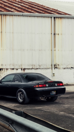 Black Nissan 240SX parked near a building