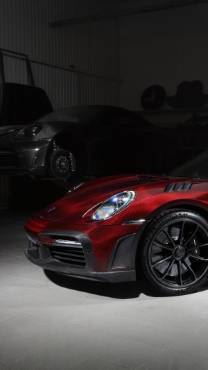 Red Porsche 911 and dark Porsche 911 in garage