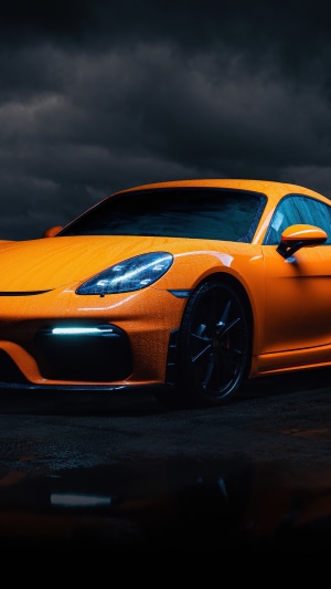 Orange Porsche Cayman GT4 RS on a dark, rainy day