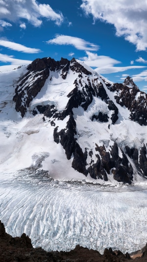 Snowy mountain peak with glacier and clouds