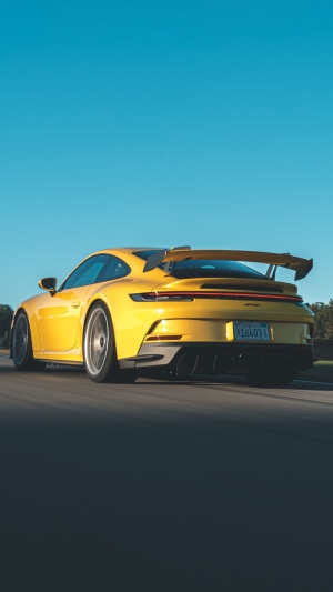 Yellow Porsche 911 GT3 driving on road