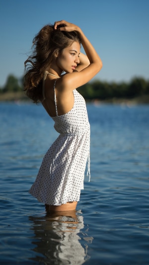 Model in polka dot dress standing in water